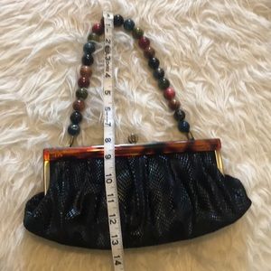 Black purse with metal/tortoise shell closure.